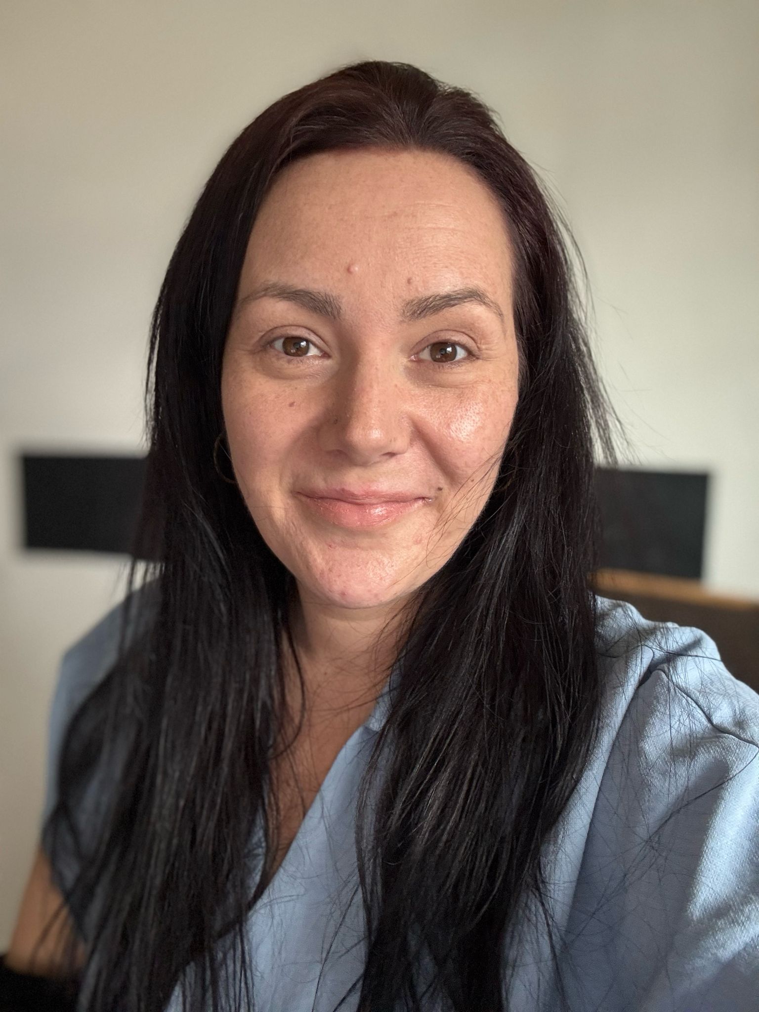 Auf dem Bild sieht man Silvia Lenk. Es ist ein Profilbild. Man sieht sie sehr nah. Man sieht sie vom Scheitel bis Brustanfang. Sie lächelt freundlich in die Kamera. Ihre fast schwarzen, langen Haare trägt sie offen. Sie hat eine jeansfarbene Bluse an und im Hintergrund sieht man eine weiße Wand mit einem schwarzen Balken.